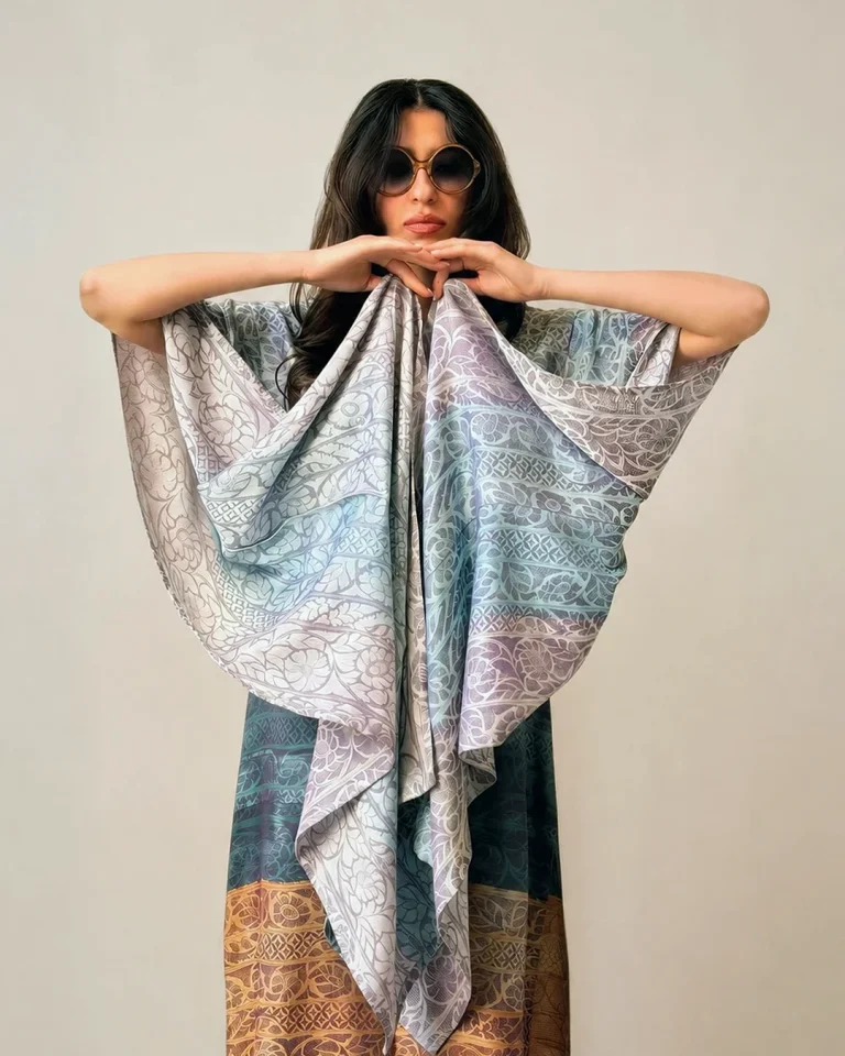 Close-up view of the upper section of the Atlas Abaya, showing flowing sleeves and delicate motifs in light blue and pale lilac tones