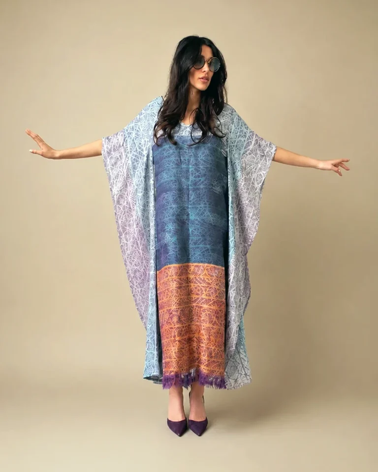 Full view of the Atlas Abaya with an elongated silhouette, patterned golden hem, and purple fringes at the lower edge