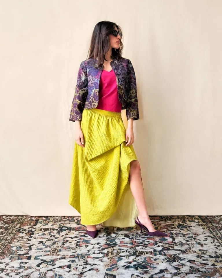 Full-length view of the Toranj Jacket and Skirt from the CUSP Spring/Summer 2026 collection, featuring a cropped patterned jacket, fuchsia top, and flowing yellow-green skirt