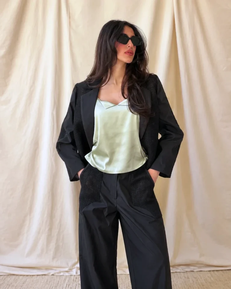 Full-standing indoor view of the Shabaq Taffeta Jacket and Trousers with a light green top and relaxed black trousers