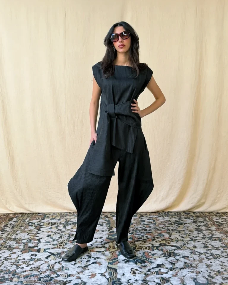 Full-body view of the Tifon pleated taffeta top and voluminous trousers in black, with asymmetric front layering