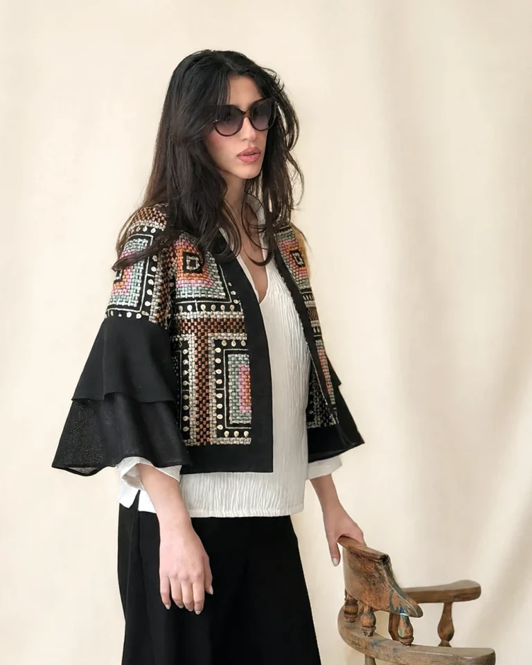 Half-body view of the Kajideh cotton jacket with geometric sequin embellishment, layered sleeves, and a white top underneath