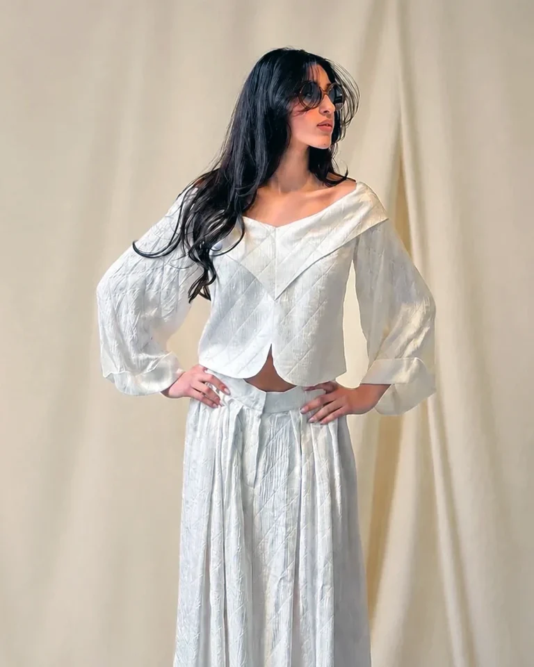 Half-body view of the Sepid blouse with an open off-shoulder neckline, angular front panels, and embossed silk texture