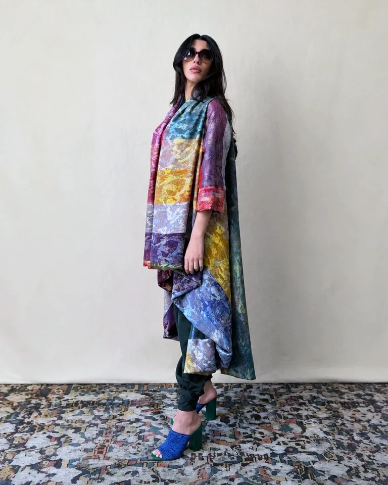 Full-length view of the Atlas Daraei Aba in multicolored handwoven silk with dark trousers and a fluid draped silhouette