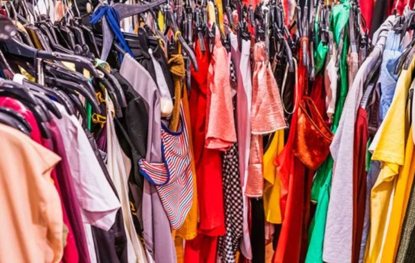 Overcrowded rack of colorful mass-produced clothing, a glimpse into the fast fashion cycle